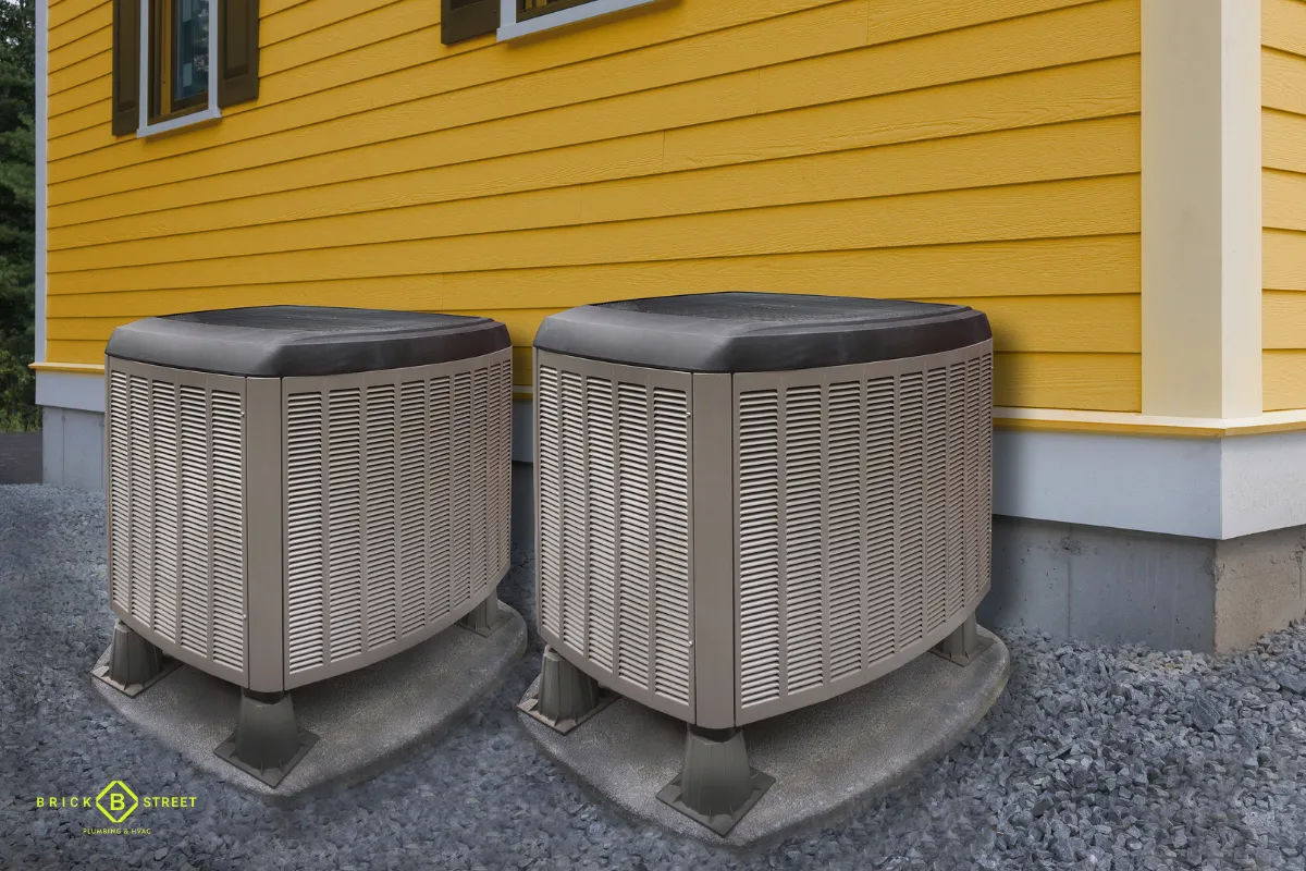 Two new AC condensers beside a home