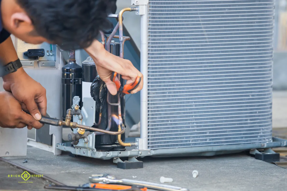 Technician repairing an outdoor AC condenser